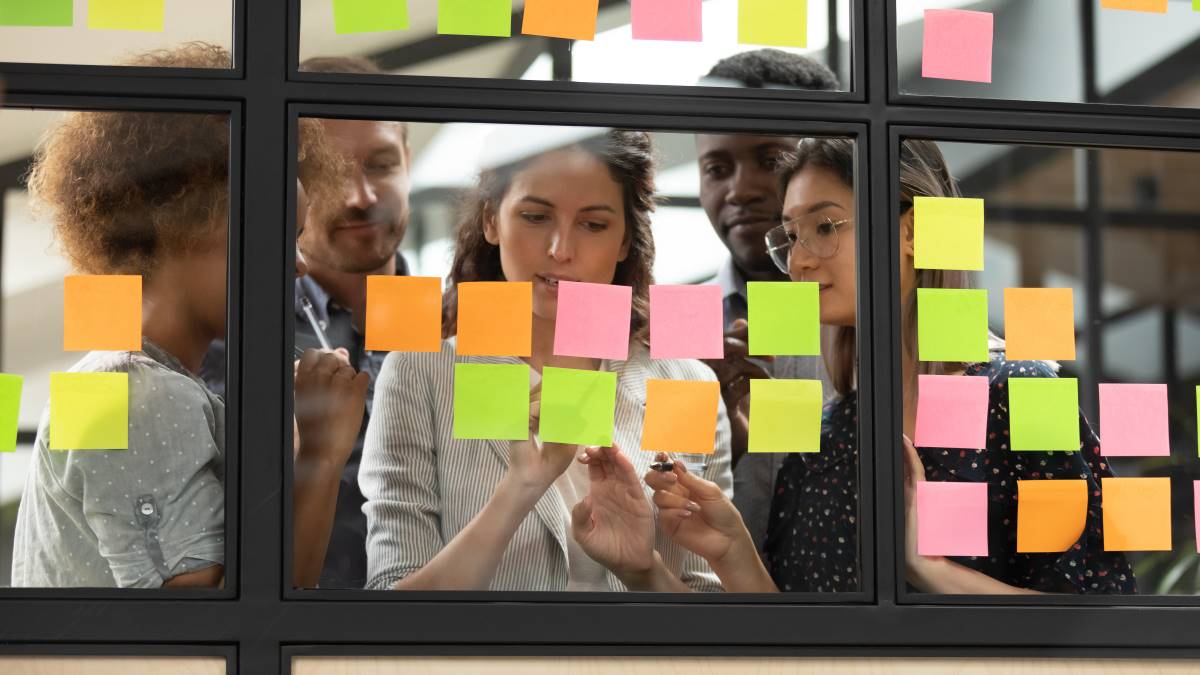 Mixed_Gender_Team_Reviewing_Project_Plans Focused young diverse teammates working with team