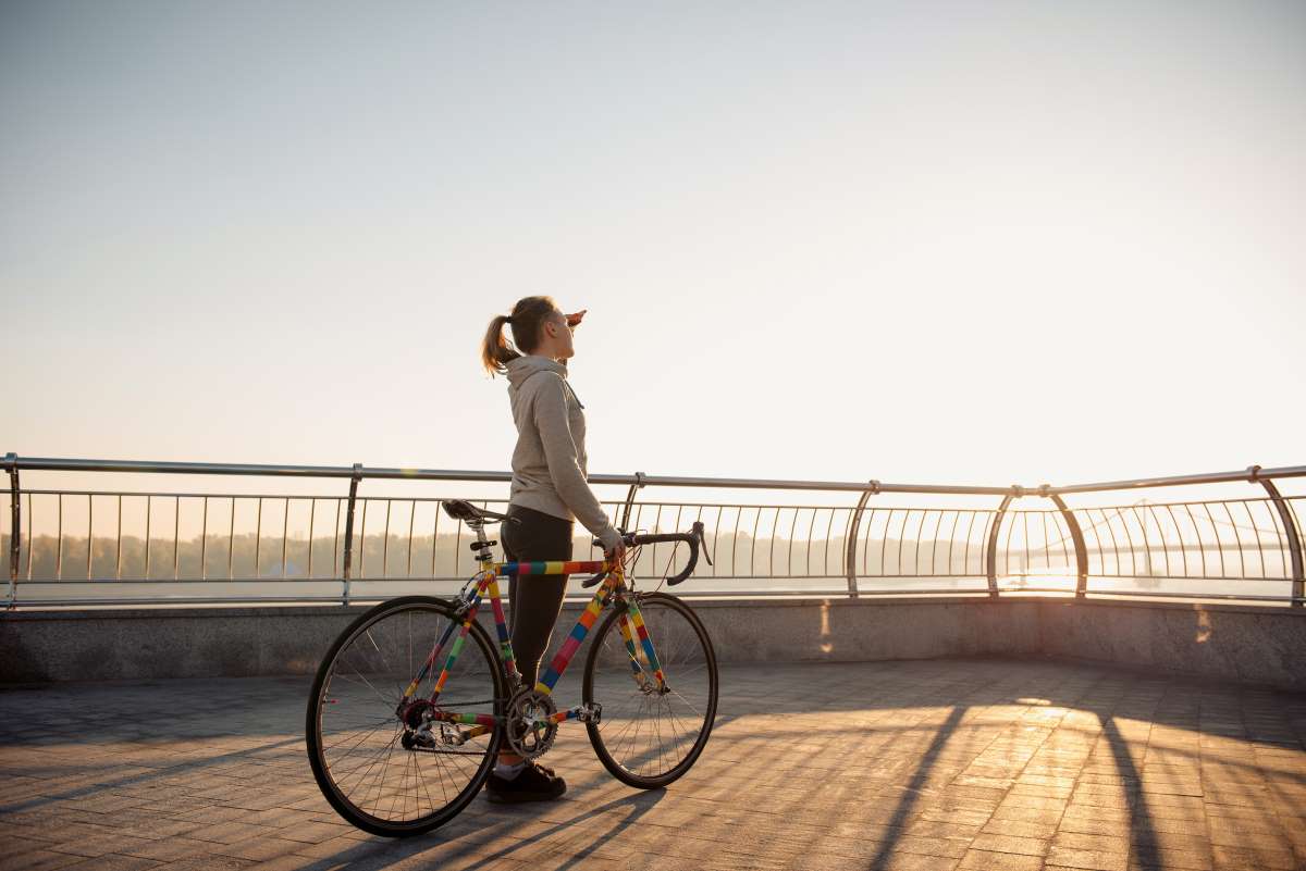 Young woman riding a bicycle in the city at sunrise Young woman riding a bicycle in the city at sunrise
