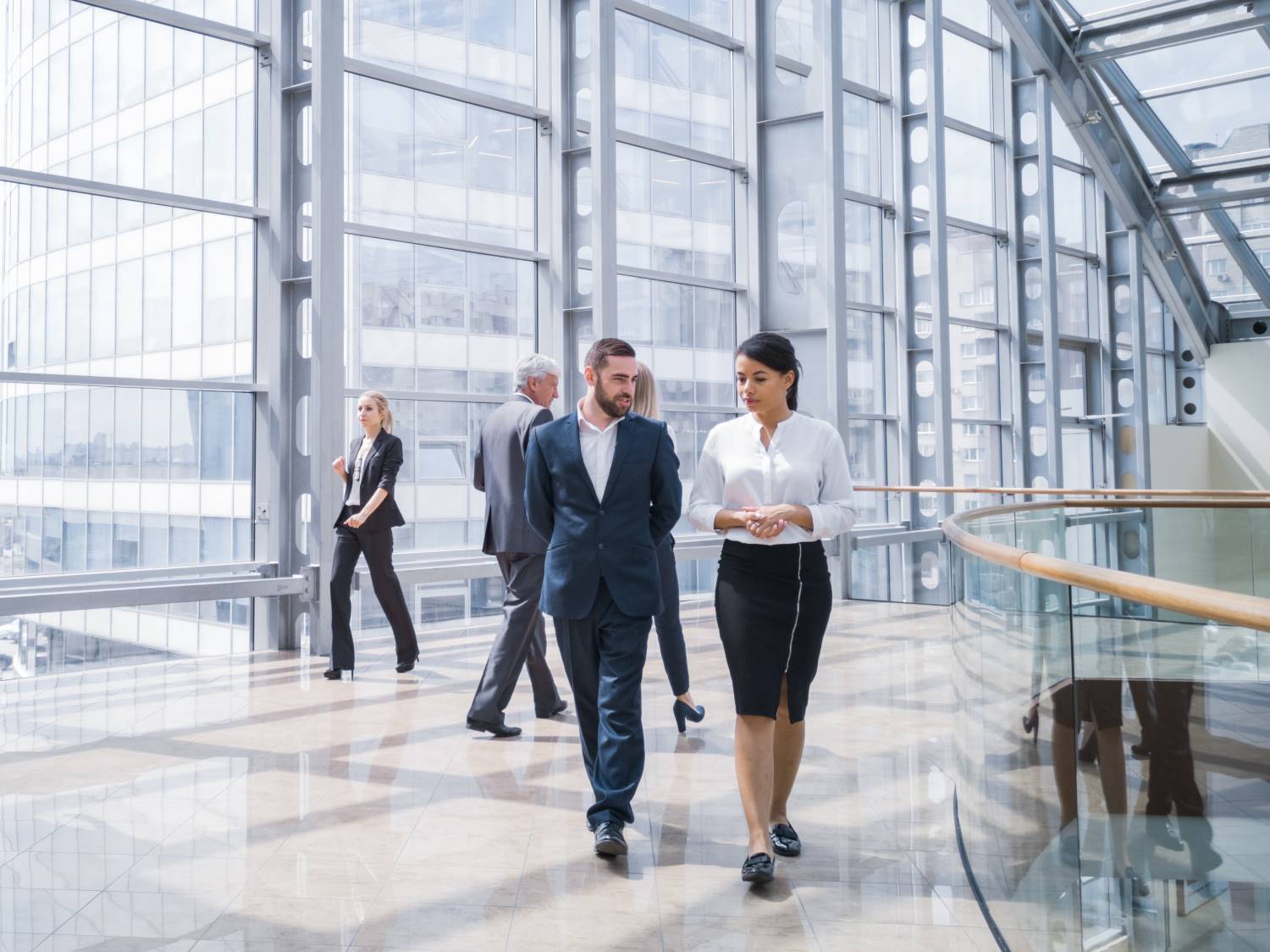 Businesspeople_Walking_Down_Glass_Hallway Business people walking in a modern hall