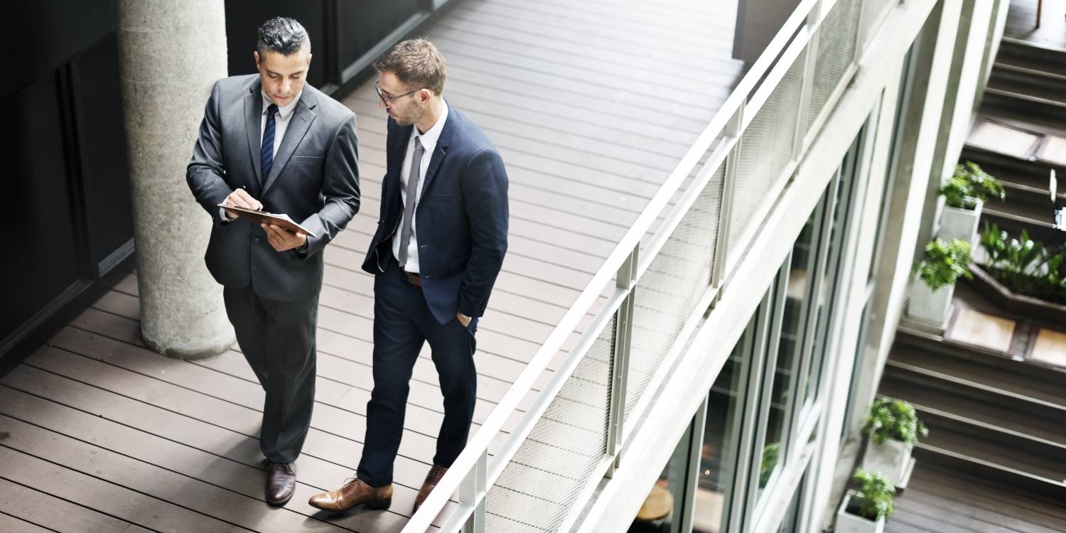 Businessmen Discussion Standing at Clipboard