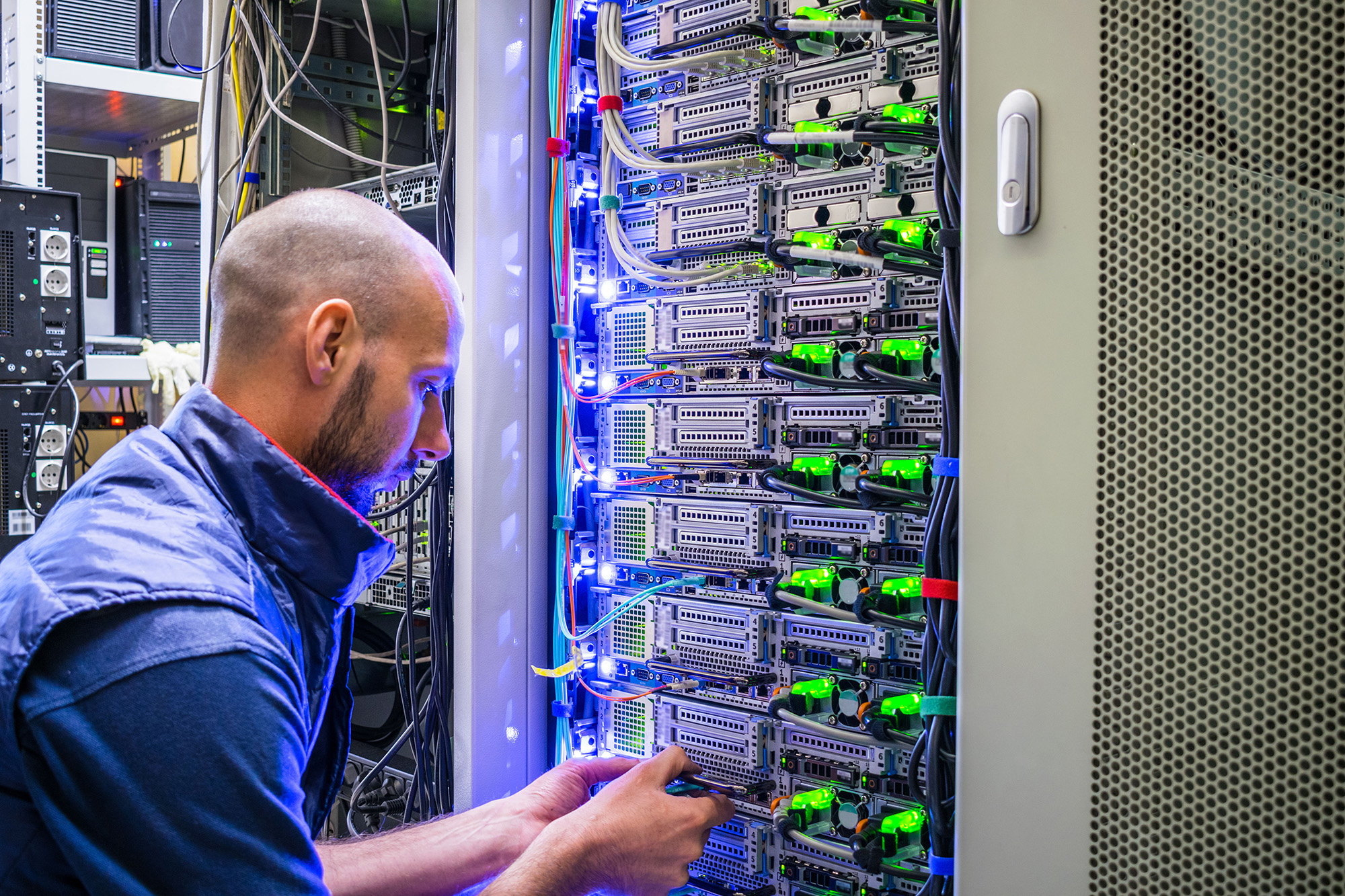 A Specialist Connects The Wires In A Server Room