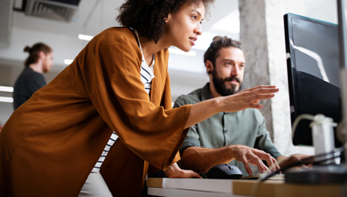 Man_And_African_American_Woman_Meeting_at_Desktop Man_And_African_American_Woman_Meeting_at_Desktop
