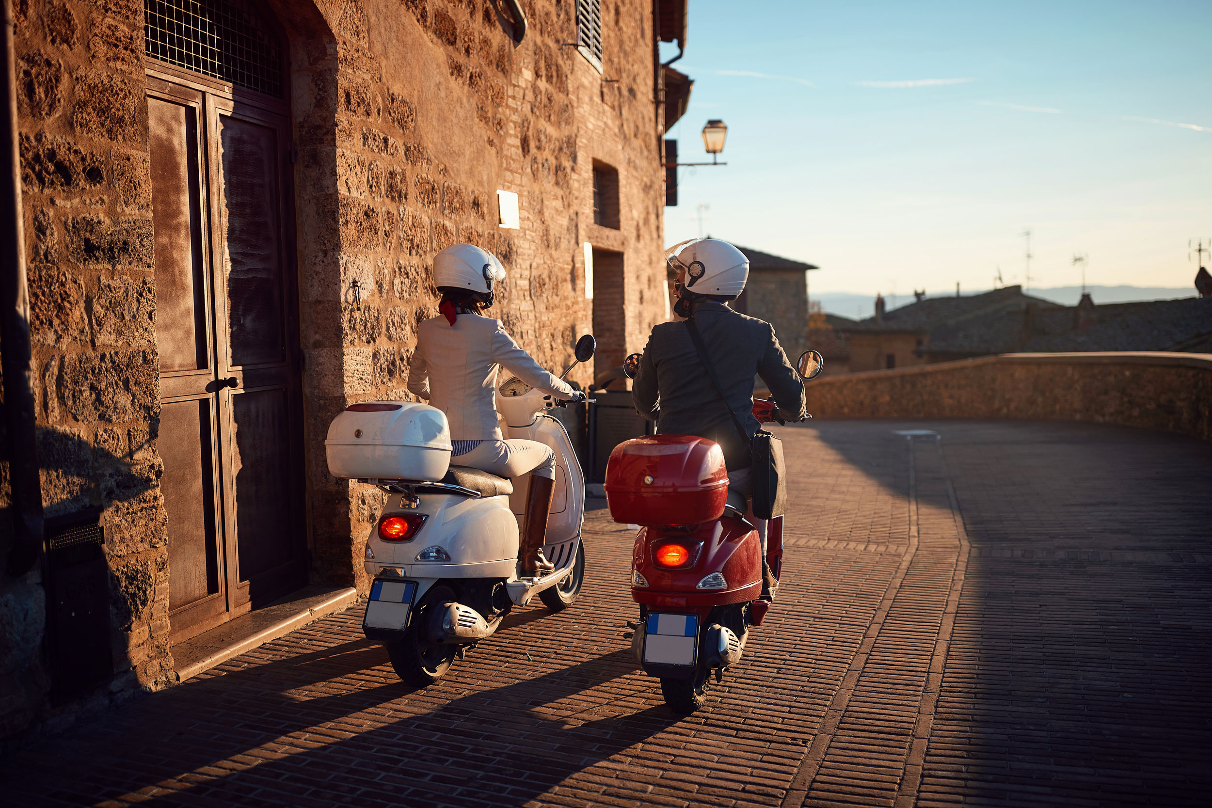 Man And Woman On Vespa Scooters