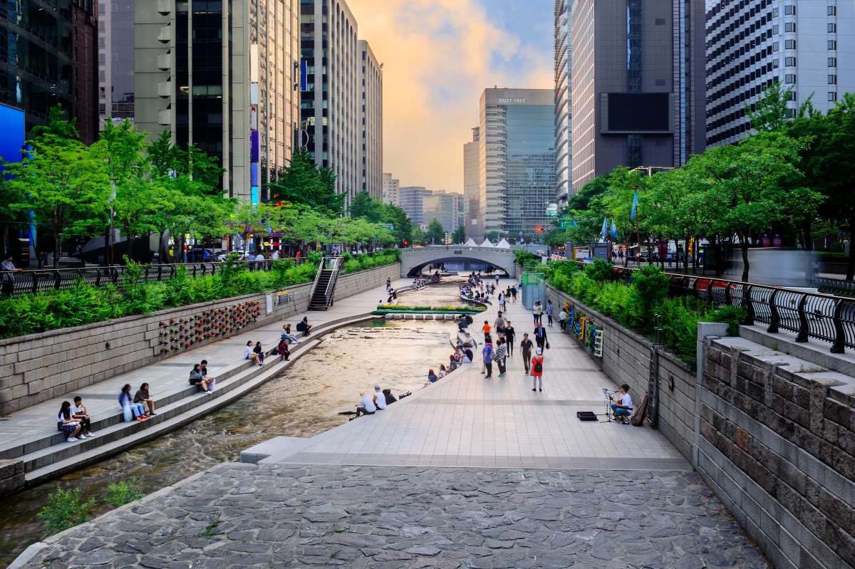 City Stream Park With Crowd At Sunset Clouds 