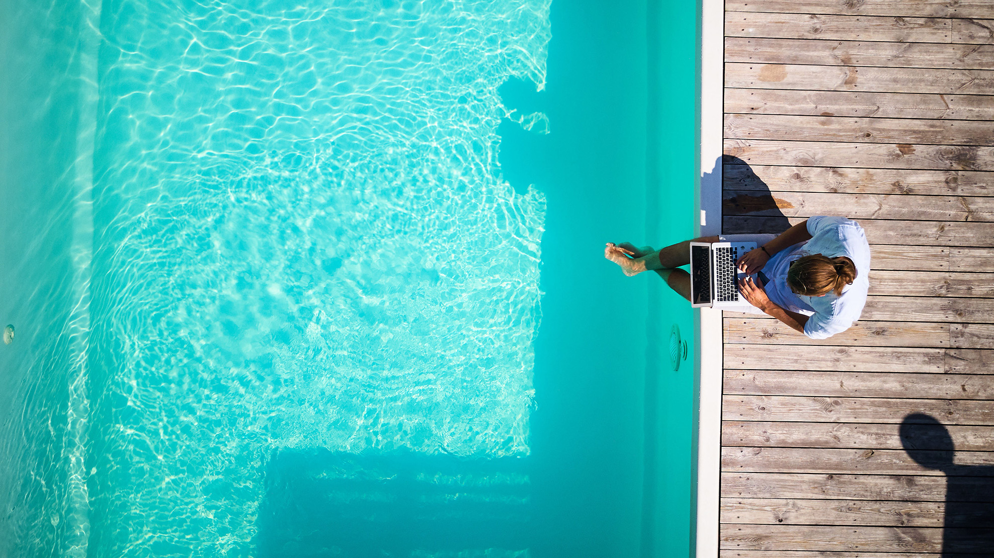 Well Dressed Male Sitting At Pool With Laptop