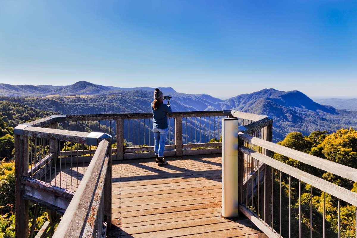Woman standing on platform overlooking mountains