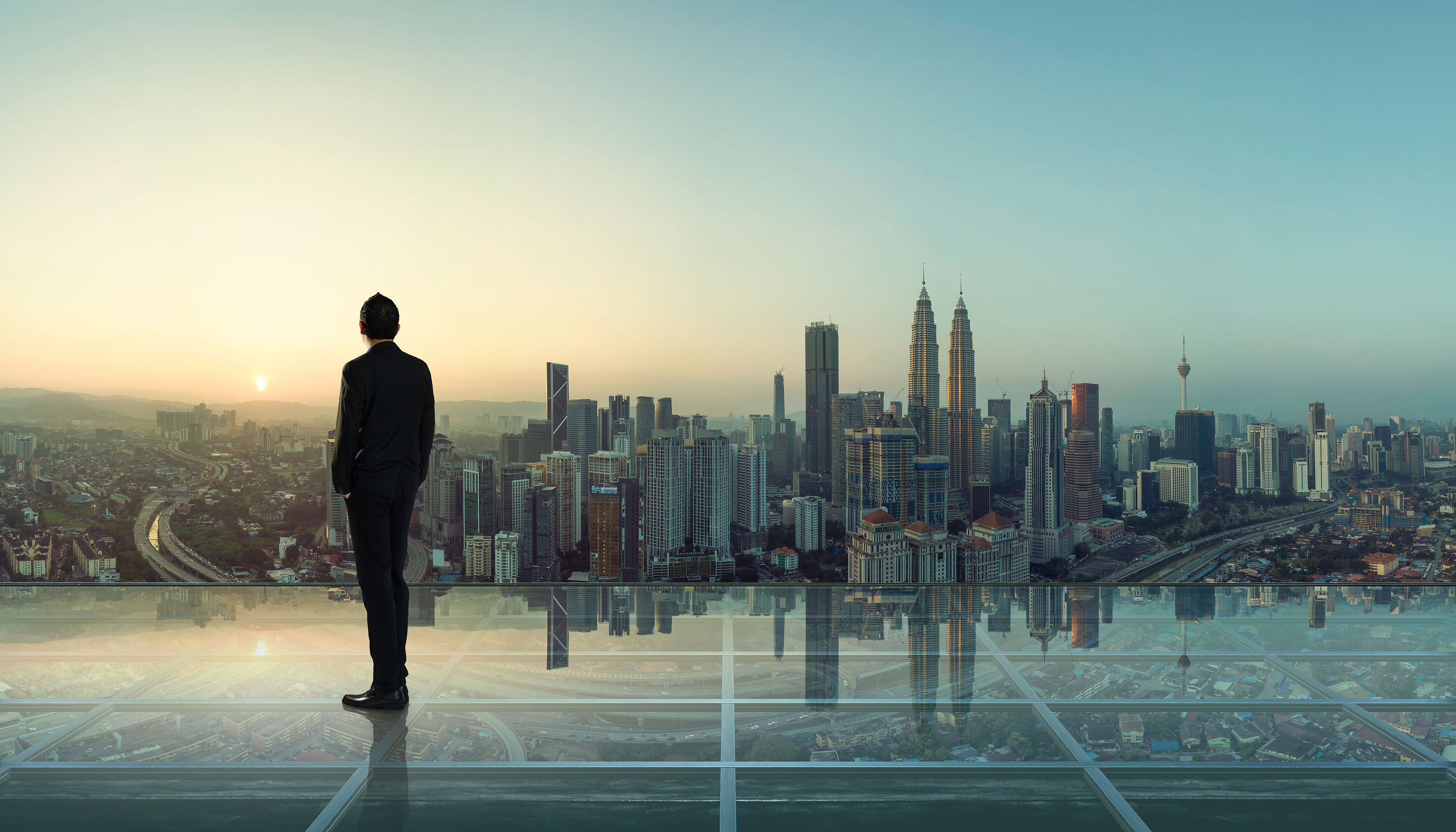 Asian_Businessman_Looking_Over_City_Skyline