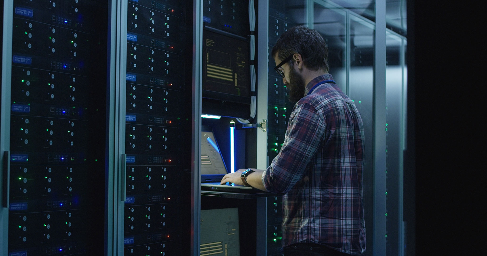 IT_Technician_In_Dark_Server_Room IT_Technician_In_Dark_Server_Room