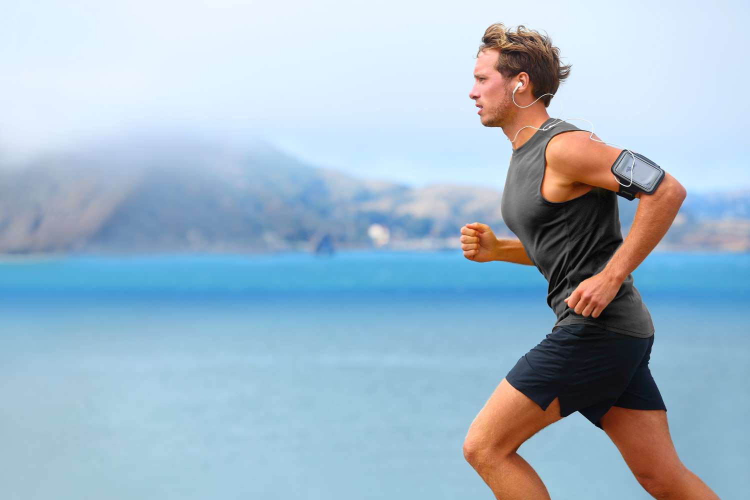 Male runner listening to music with phone armband 
