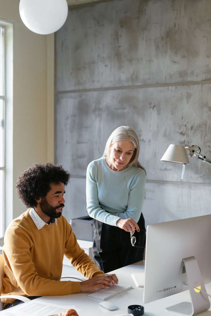 Man and woman look at computer screen