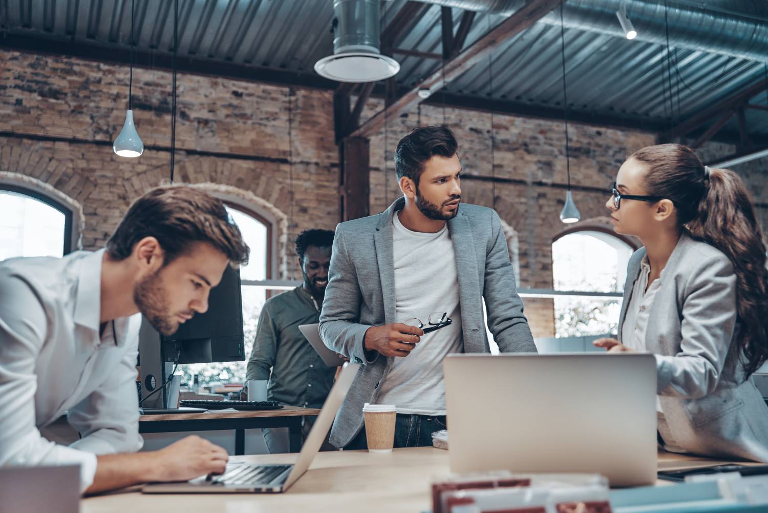 Mixed_Gender_Businesspeople_in_Open_Space_Floorplan group of people using modern technologies
